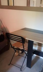 a wooden table with a chair in a room at Chambre-coin repas, sous terrasse, Proche gare in Franconville