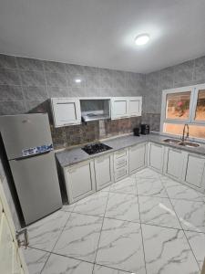 a kitchen with white cabinets and a refrigerator at Dartoumana Ogla Zarzis EL Bahia in Sangho