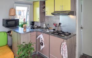 a small kitchen with a sink and a refrigerator at 3 Bedroom Nice Stacaravan In Trégunc in Trébérouant