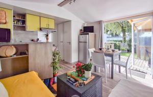 a kitchen and living room with a table and a refrigerator at 3 Bedroom Nice Stacaravan In Trégunc in Trébérouant