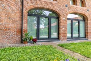 a brick building with large windows and a potted plant at La Montagnola in Castelfranco Veneto