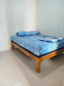 a bed with blue sheets and blue pillows on it at Bromo Jay House Homestay IV in Sukapura