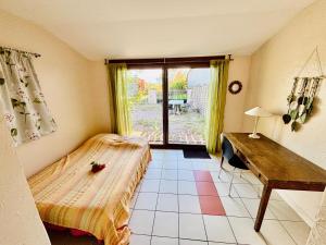 a bedroom with a bed and a table and a window at Le bienvenu - 90m2 4 chambres - Gites Montvaltin in Le Breuil