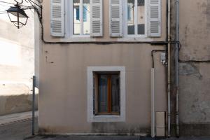 un bâtiment avec volets blancs et fenêtre dans l'établissement Bâtiment Les Iris, à Bourg-Saint-Andéol
