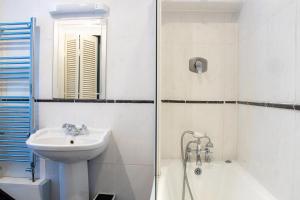 a white bathroom with a sink and a shower at GuestReady - Quiet Dublin Getaway in Dublin