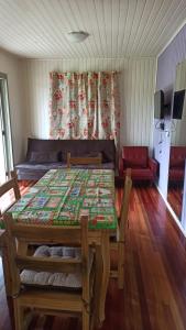 Un comedor con una mesa y un sofá. en Chalé Paraíso Da Serra 02, en Gramado