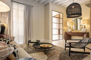 ein Wohnzimmer mit einer Couch und zwei Tischen in der Unterkunft Villa Cas Pilot Casa Mallorquina del Siglo XVIII NEW OPENING in Son Servera