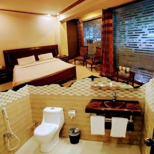 Un dormitorio con una cama y un baño con inodoro. en Hotel Gulberg Lodges MM Alam Road Gulberg ,Cavalry Lahore, en Lahore