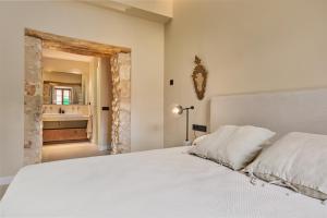 a bedroom with a bed and a bathroom with a sink at Villa Cas Pilot Casa Mallorquina del Siglo XVIII in Son Servera