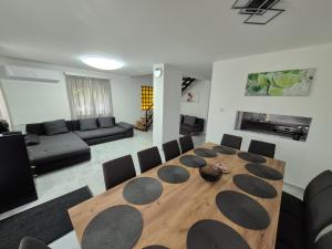 a living room with a wooden table and chairs at Grand Alba apartman Mezőkövesd Zsóry in Mezőkövesd