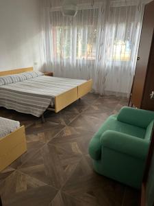 una camera da letto con un letto e una sedia verde di Casa di Paolo a Castrocaro Terme