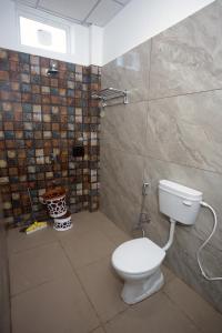 a bathroom with a toilet and a shower at Prem Sadan, Pandokhar Sarkar Dham in Indargarh
