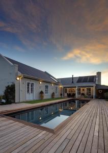 a house with a swimming pool on a wooden deck at Pelicans Nest in Onrus in Hermanus