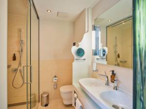 a bathroom with a sink and a shower and a toilet at Giardino Lago Bed&Breakfast in Minusio