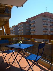 une table bleue et des chaises sur un balcon avec des bâtiments dans l'établissement Amalia's Home, à Bari