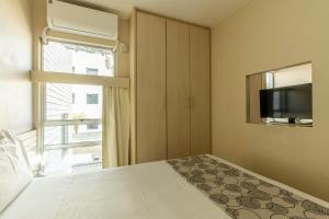 a bedroom with a bed and a tv and a window at Verona Hplus Long Stay in Brasilia