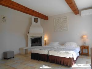 a bedroom with a bed and a fireplace at Clos des Lavandes - Chambres et Suites de charme climatisées-Luberon in Lacoste