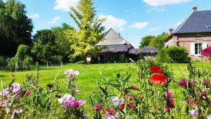 ein Blumenfeld vor einem Haus in der Unterkunft Chalet 15 pers écologique et moderne de 7 chambres à 15 km de la mer in Bernay-en-Ponthieu