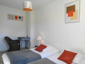 a hotel room with two beds and a chair at Clos des Lavandes - Chambres et Suites de charme climatisées-Luberon in Lacoste