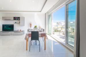 a dining room with a table and a large window at New Spacious Apartment 3 Bdr 2 Bth Bugibba S in St Paul's Bay