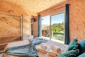 a bedroom with a bed with a large window at Quintinha Da Aldida - Gerês in Vieira do Minho