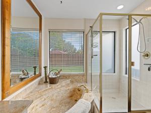 a bathroom with a tub and a glass shower at North Dallas Retreat - 3 BR - Spacious Backyard in Addison +43 photos
