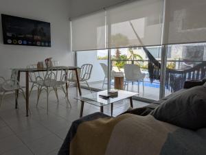 アカプルコにあるAdults Only Condo Close to the Beachのソファとテーブルと椅子のあるリビングルーム