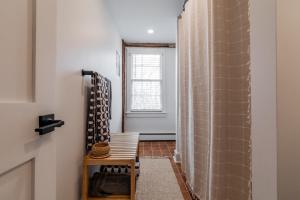 a bathroom with a shower with a chair and a window at The Old Bell Tavern - Luxury Meets History in New Gloucester +28 photos