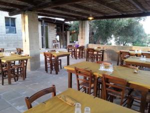 an empty restaurant with wooden tables and chairs at La Trottoria Agriturismo in Otranto