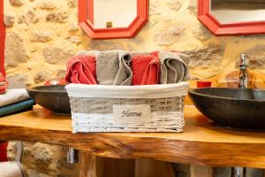 a basket of towels sitting on a table next to two bowls at Gîte Le Bouton D'or 8min Puy du Fou in Chambretaud +15 photos