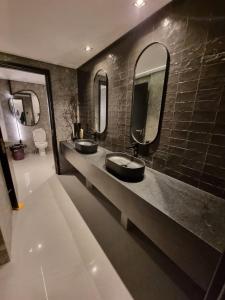 a bathroom with two sinks and two mirrors at Flat Elegante c/ Varanda e Vista Mar - Tambaú in Tambaú