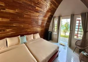 una camera da letto con un letto e una parete di legno di Resort Hoa Loi a Vĩnh Cửu Lỏi (1) Altre 53 foto