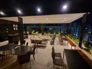 a restaurant with tables and chairs on a rooftop at Flat Elegante c/ Varanda e Vista Mar - Tambaú in Tambaú