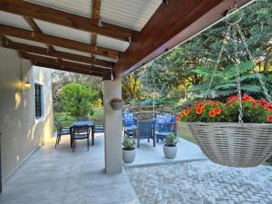 a patio with chairs and a table with flowers at Courtleigh Cottage in Hilton