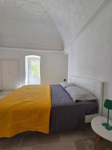 a bedroom with a large bed with a yellow blanket at Loco Holiday - Don Rosario in Locorotondo +22 photos