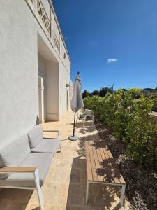 a patio with chairs and an umbrella and a table at Loco Holiday - Don Rosario in Locorotondo