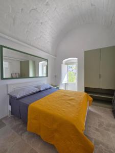 a bedroom with a large bed with a yellow blanket at Loco Holiday - Don Rosario in Locorotondo