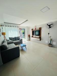 a living room with a couch and a tv at Casa de praia SANTINHO in Búzios +47 photos