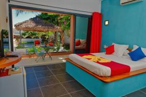 a bedroom with a bed with a view of a patio at Résidence Sarimanok in Nosy Be +24 photos