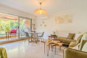una sala de estar con un sofá y una mesa en Charming 80m for 6 people with garden, en Cros-de-Cagnes