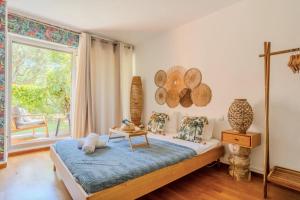 Un dormitorio con una cama y una ventana grande. en Charming 80m for 6 people with garden, en Cros-de-Cagnes