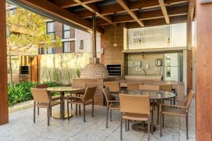 eine Terrasse mit Tischen und Stühlen und eine Küche in der Unterkunft Vista Park Hplus Long Stay in Brasilia