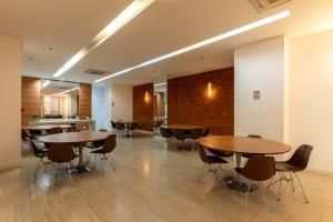 ein Zimmer mit Tischen und Stühlen sowie einer Küche in der Unterkunft Vista Park Hplus Long Stay in Brasilia + 81 Fotos