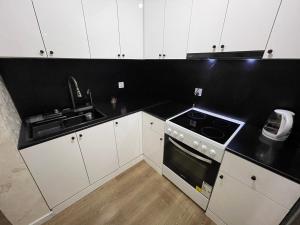 Una cocina con gabinetes blancos y una encimera negra. en Sunrise Guesthouse UB, en Ulán Bator