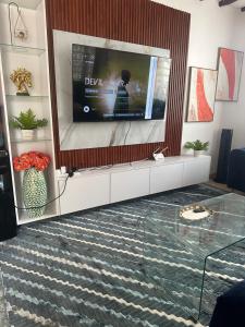 a living room with a flat screen tv on a wall at Sea la vie - Macheo in Ukunda