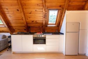 a kitchen with a stove and a refrigerator at Las casitas de mache - LAROCA in Cerler