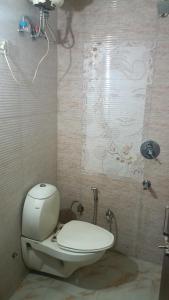 Un baño con un inodoro blanco en una habitación. en Hotel Clark, en Nueva Delhi