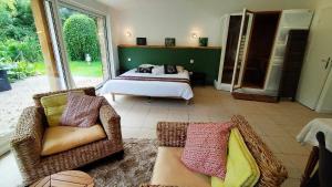 ein Schlafzimmer mit einem Bett, einer Couch und Stühlen in der Unterkunft Loft Ginkgo in Bernay-en-Ponthieu