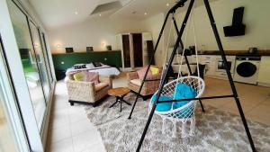 ein Wohnzimmer mit einem Zimmer mit einem Bett und Stühlen in der Unterkunft Loft Ginkgo in Bernay-en-Ponthieu