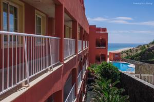 コスタ・カルマにあるResidence Playa Paraiso with Ocean View - Cobalt Flatの海を見渡せるバルコニー付きの赤い建物 +3枚の写真
